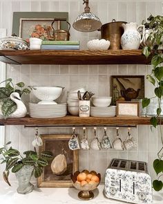 the shelves are filled with dishes and other kitchen utensils, including an old fashioned toaster