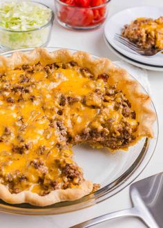 a cheeseburger pie on a plate with a slice cut out and ready to be eaten