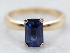 a tan gold ring with a blue sapphire stone