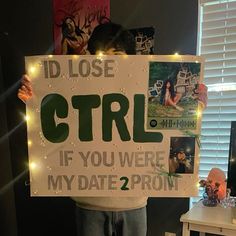 a young boy holding up a sign that says i'd lose ctrl if you were my date 2 prom