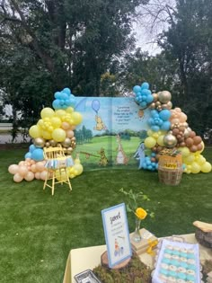 winnie the pooh birthday party with balloons and desserts on display in front of an open book