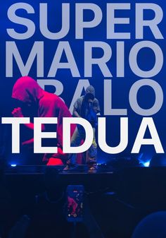 a man standing on top of a stage in front of a crowd with the words super mario sallo tedua