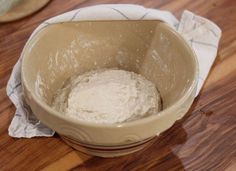 a bowl filled with flour on top of a wooden table