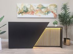 a black and gold sideboard next to a potted plant in a living room