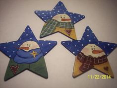 three wooden stars with snowmen painted on them