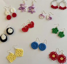 several pairs of crocheted earrings are displayed on a table