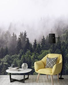 a yellow chair sitting in front of a forest wallpapered with fog and trees