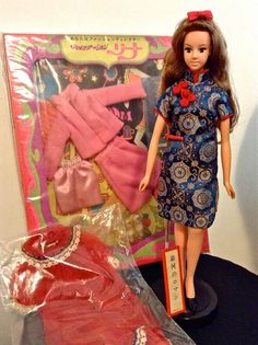 the doll is wearing a blue dress and red shoes