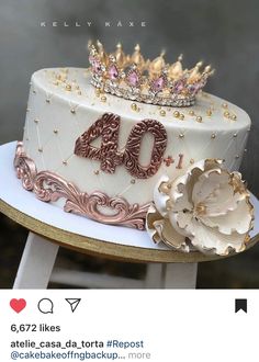 a white cake with gold decorations and a tiara on top that says forty likes