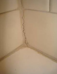 the corner of a room that has some cracks in it