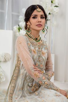 This dramatic ensemble features a jacquard silk net crushed floor- length peshwas, a long straight-cut over lay net shirt featuring bold floral resham & tila embroidery further enhanced with dabka, sequins, pearls and bead work, artfully embroidered sleeves and Chevron embroidered border on side hem with hand crafted tassel completes the look. This look is completed with net dupatta featuring heavy sequin embellishments and hand work motifs all over. Shirt & dupatta Fabric: Net Shirt Length: 48” Net Shirt, Designer Outfit, Over Shirt, Embroidered Sleeves, Embroidered Border, Net Dupatta, Pakistani Designers, Hand Work, Straight Cut