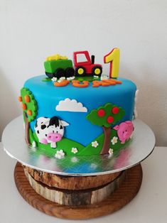 a birthday cake with a tractor and farm animals on the top is sitting on a wooden stand