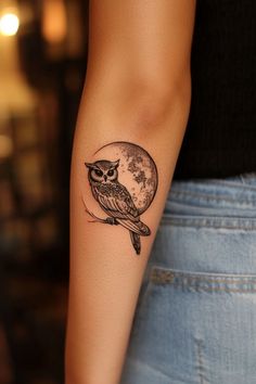 a small owl tattoo on the left arm and right arm, it has a full moon in the background