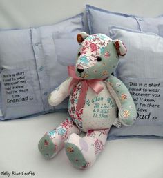 a blue teddy bear sitting next to two pillows