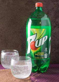 a bottle of soda and two glasses on a table