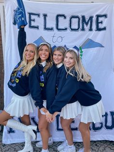 the girls are posing in front of a welcome banner