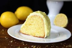 a piece of cake on a plate with lemons in the background and one slice missing