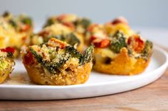 several small muffins on a white plate with broccoli and other toppings