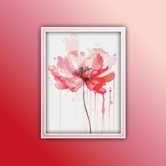 a pink flower with watercolor paint splattered on it's petals is displayed in a white frame