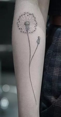 a dandelion tattoo on the left arm