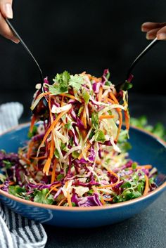 someone is cutting into a salad in a blue bowl