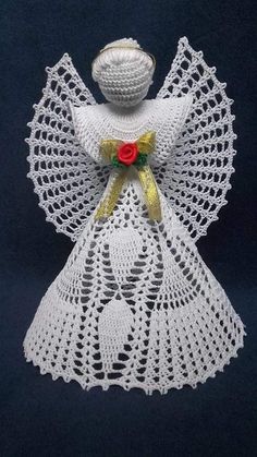 a crocheted angel with a red rose on it's chest and wings