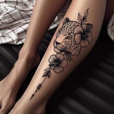 a woman's leg with a leopard and flowers tattoo on it