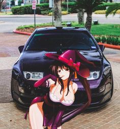 a woman sitting on the ground in front of a car wearing a hat and dress