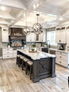 a large kitchen with white cabinets and marble counter tops, an island in the middle