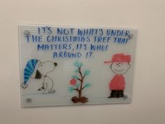 a glass sign that says it is not what's under the christmas tree that matters, it's who around it