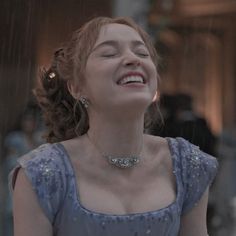 a woman laughing in the rain with her eyes closed and head tilted to the side