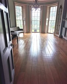 an empty living room with wood floors and large doors leading to the front door area