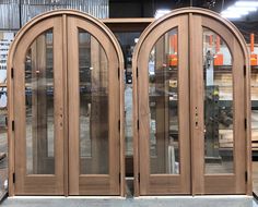 two wooden double doors in front of some pallets and other woodworking equipment at a factory