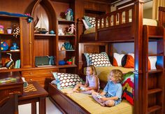 a bedroom with bunk beds and desks in it