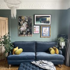 a living room with blue couches and pictures on the wall