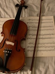 an old violin is laying on the sheet music