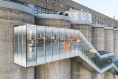 an orange crane is reflected in the glass on the side of a building that looks like it has been built into concrete