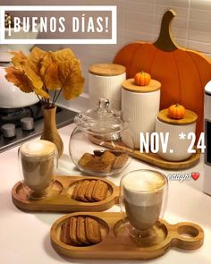 there are cookies and cups on the counter with pumpkins in the backround