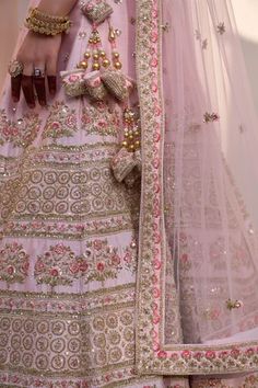 Blush pink lehenga with traditional zardozi technique using silken threads, dabka, cutdana and sequins work in stripe pattern. Paired with blouse and two dupattas.
Component: 4
Pattern: Embroidery
Type Of Work: Zardozi, silk thread, dabka, cutdana, sequin, floral
Neckline: Leaf neck
Sleeve Type: Half
Fabric: Raw Silk
Color: Pink
Other Details: 
Side and back tassel tie-up
Sheer embroidered dupatta
Occasion: Bride - Aza Fashions Pink Katan Silk Lehenga With Cutdana Detail, Pink Raw Silk Lehenga With Intricate Embroidery, Pink Unstitched Lehenga With Cutdana, Pink Semi-stitched Lehenga With Cutdana, Ceremonial Pink Lehenga With Cutdana Detail, Raw Silk Embroidery, Embroidery Zardozi, Pink Lehenga, Lehenga Blouse