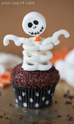 a cupcake decorated like a skeleton on top of it