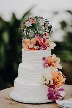 a white wedding cake with flowers on top