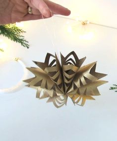 a hand holding an ornament that looks like a flower