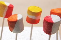 colorful marshmallows are arranged on sticks with white and red stripes in the middle