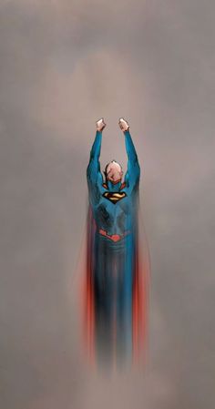 a man dressed as superman flying through the air with his hands up in the air