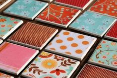 many different colored tiles are arranged on the table together, with dots and flowers in them