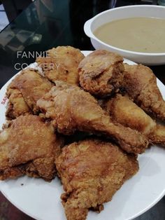 fried chicken on a white plate next to a bowl of soup