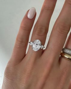 a woman's hand with two rings on it and a diamond ring in the middle