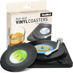 an old record player and glass of orange juice are in front of the packaging for vinyl coasters