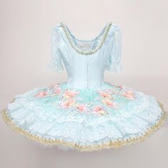 Extremely delicate and refined pal blue version of the Fairy Doll professional tutu. Round neck and pale blue satin fitted bodice that fastens with a double row of hooks and eyes in the back. Round back. The decoration on the bodice is very elegant, with golden trims, crystals and flower appliques. The three-quarter sleeves are made with pale blue lace. The hooped, ten layers tutu skirt, is made with high quality pale blue tulle. Decorations are made with several rows of white lace, flower appli Fitted Blue Tutu Dress For Wedding, Blue Fitted Tutu Dress For Costume, Light Blue Fitted Tutu Dress For Wedding, Fitted Light Blue Tutu Dress For Wedding, Fitted Blue Balletcore Dress, Ballet Style Ruffled Dance Dress, Ballet Style Dance Dress With Ruffles, Tulle Decorations, Back Round