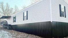 a white house with green shutters on the side